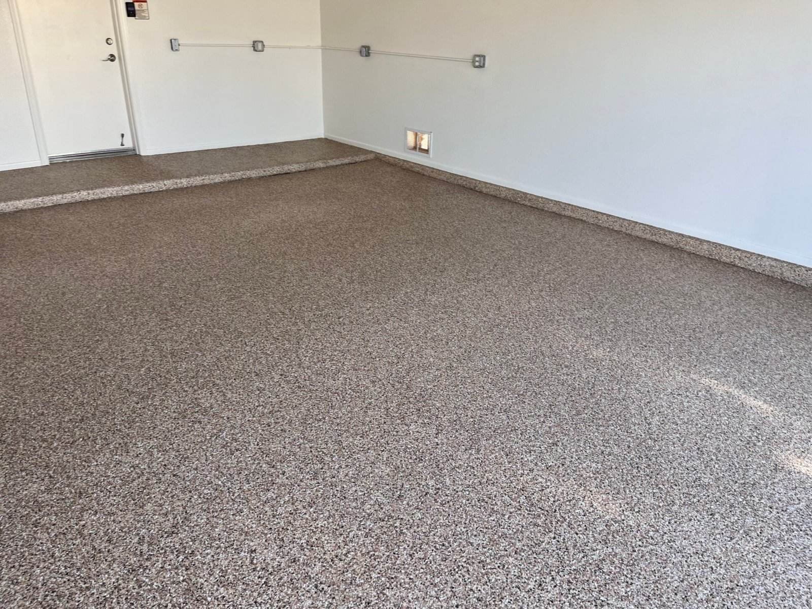 Flake epoxy garage floor with the coating carried up the stem wall and step at an Arizona home, installed by AZF Experts